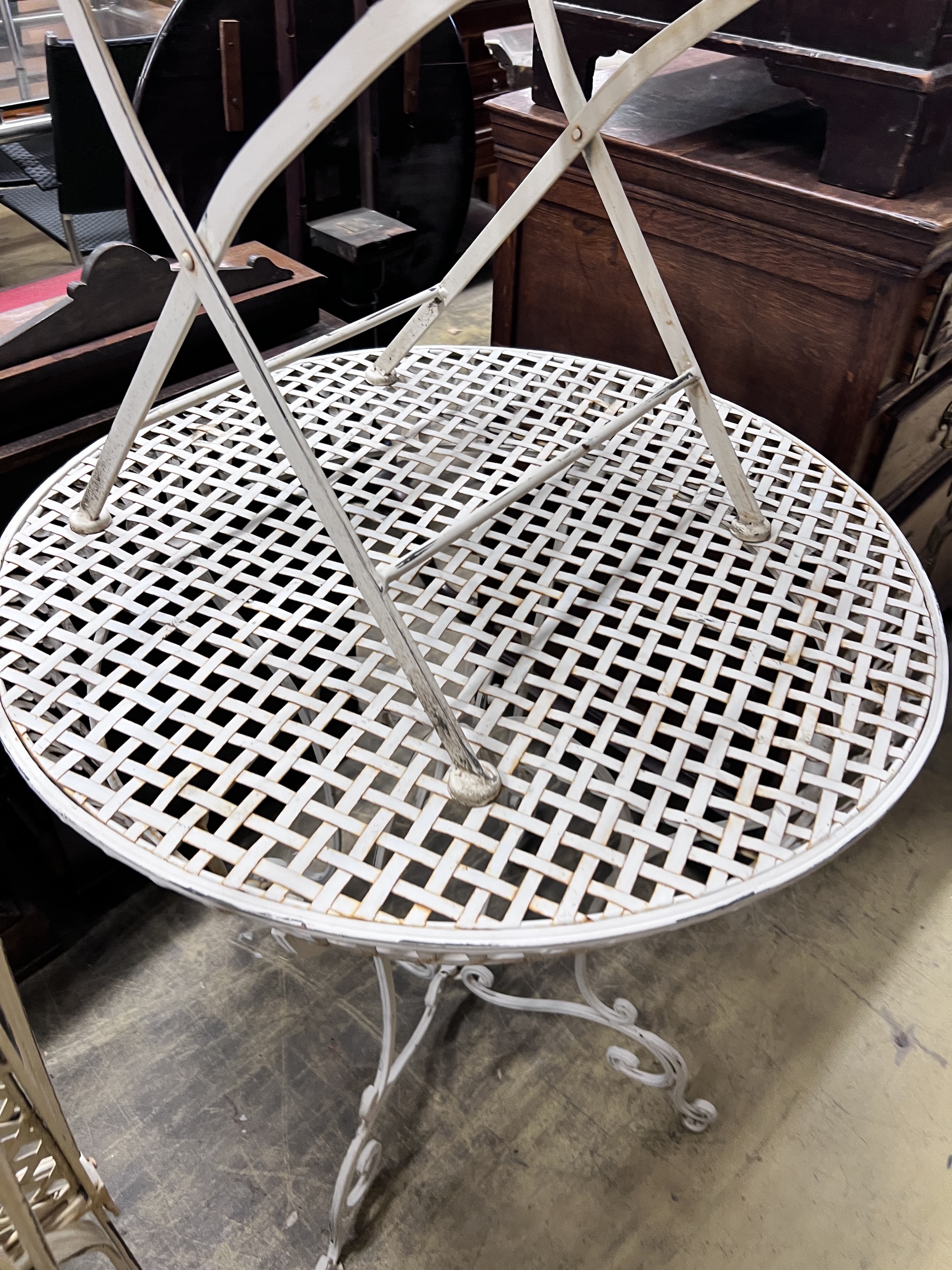 A white painted wrought iron garden table and four folding chairs